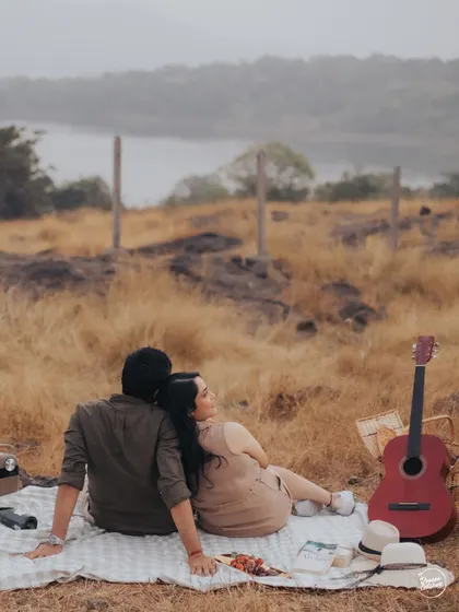 A peaceful scene of a couple enjoying a picnic overlooking a serene lake in Lonavala. This photo captures the essence of a quiet, romantic getaway, perfect for a pre-wedding shoot.