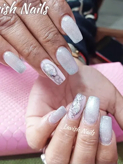 Icy silver glitter nails paired with a delicate silver and white abstract design on an accent nail, creating a cool and modern look.