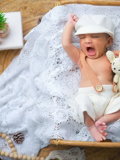 Another adorable yawn, this time with a little cap and a stuffed bunny. These small additions to the setup add a touch of whimsy to the portrait.