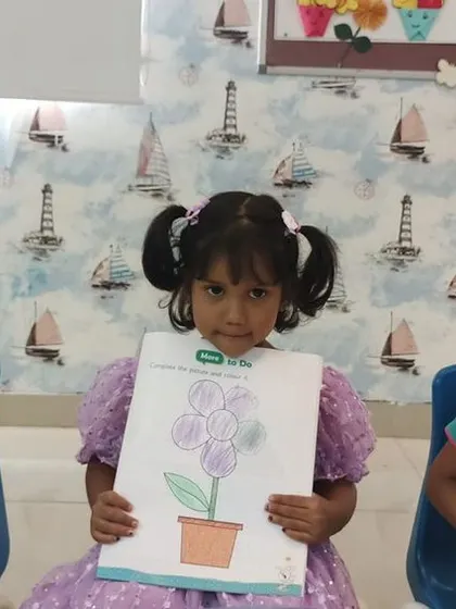 Students proudly display their finished purple flower paintings, a result of their creative efforts.