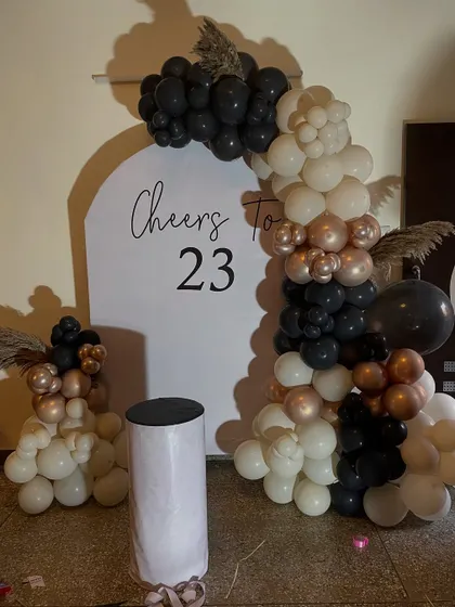 A chic and minimalist birthday backdrop for a 23rd birthday, using a sophisticated palette of black, white, and rose gold.