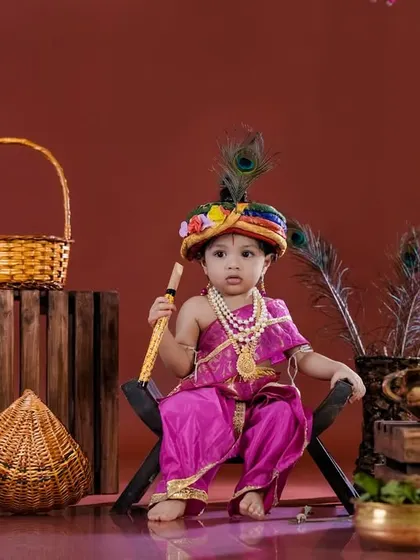 A little Krishna sitting regally on a stool, surrounded by traditional props. We pay close attention to detail in our themed setups.