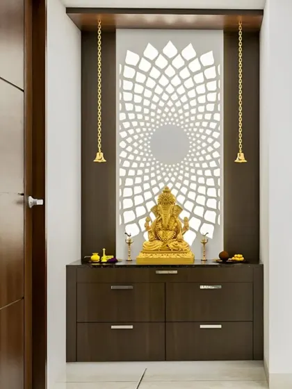 A modern pooja unit with a dark wood finish. The highlight is the back-lit circular jali panel, which creates a beautiful focal point behind the Ganesha idol.