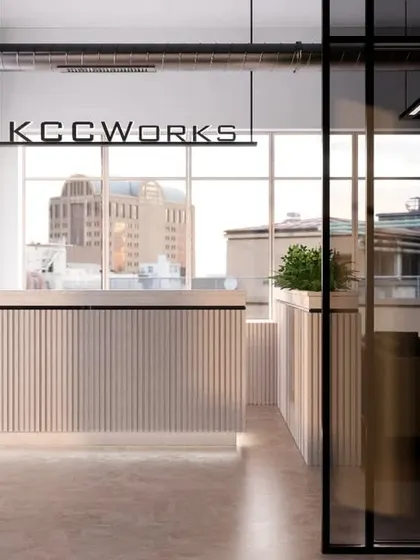 The reception design for KCC Works, a co-working space in Gurgaon. The minimalist desk and glass partitions create a sleek, professional entry for multiple businesses.