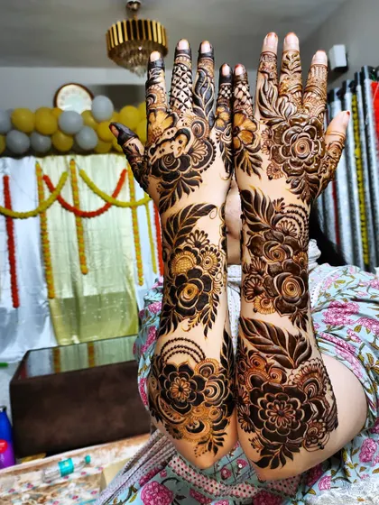 A dense floral design covering the hands and forearms, perfect for a wedding guest or festive occasion.