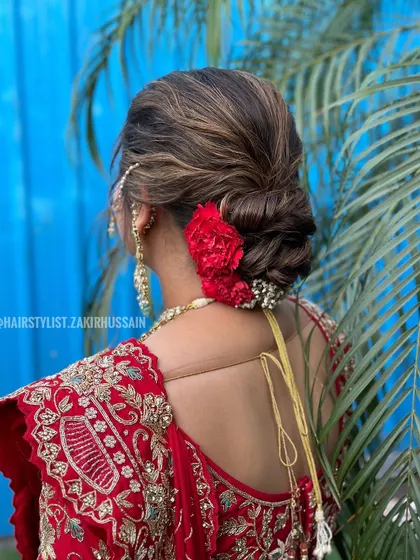 A variation of a floral bun, this style uses a single, large red flower as a focal point. It's a bold and confident choice for a bride who wants a touch of drama in her look.