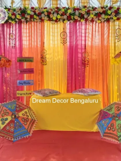 A fun and colorful Mehendi ceremony decor. The bright drapes, dreamcatchers, and Rajasthani umbrellas create a bohemian and festive vibe.