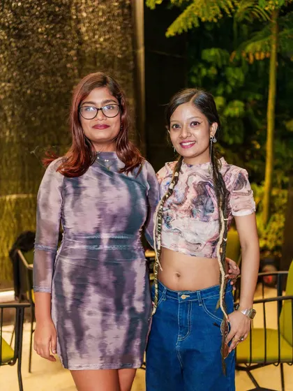 Two friends posing in front of the waterfall feature at ICB, a great backdrop for photos.