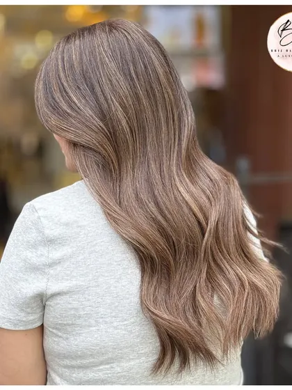 A side view of the ash blonde look, highlighting the seamless blend from roots to ends.