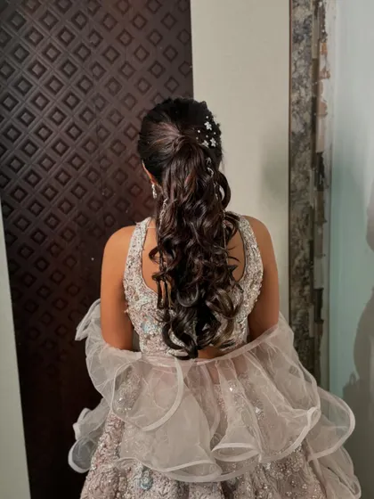 A full view of the back of the sangeet hairstyle, showing the placement of the star clips and the beautiful, bouncy curls.
