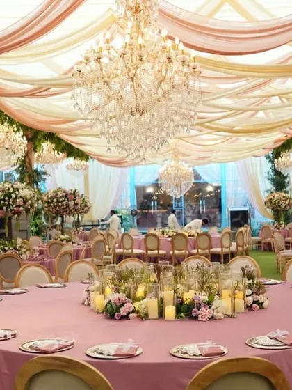 The reception dining area was set up on the lawn under a tent with a ceiling of draped pink and ivory fabric and crystal chandeliers. The round tables encourage conversation among guests.