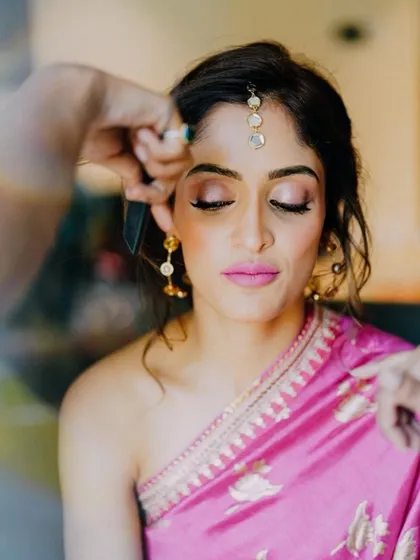 A close-up of the makeup application. We used soft pink and shimmer on the eyes to complement the bold lip, keeping the look balanced and beautiful.