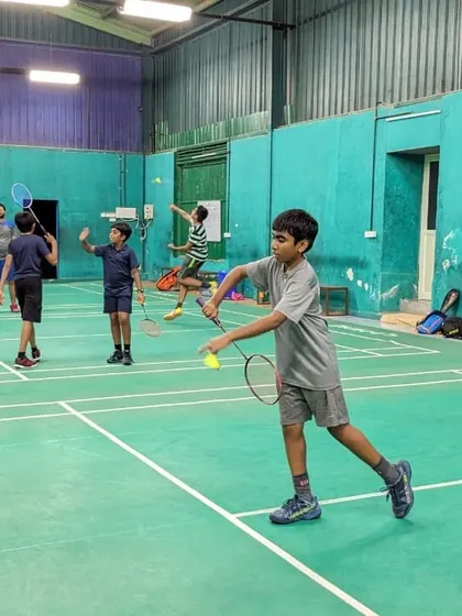 A group of junior players engaged in various drills on the court, showcasing a typical dynamic training session.