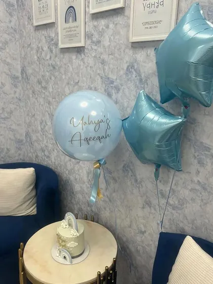 This simple and sweet balloon bunch was part of the decor for a baby's Aqeeqah ceremony. The light blue color scheme perfectly matched the cake and the room's decor.