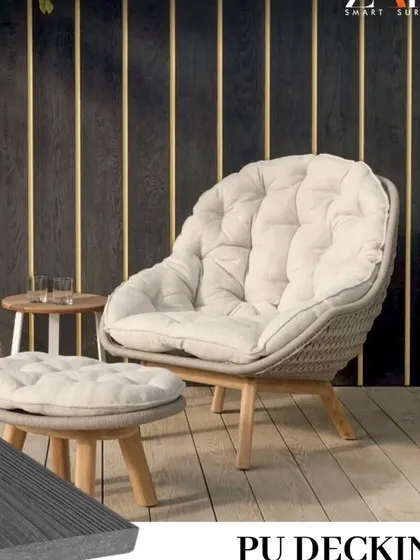 A cozy corner of a patio featuring my grey PU decking. The neutral, weathered wood look of the deck complements the modern furniture and dark louvered wall paneling.