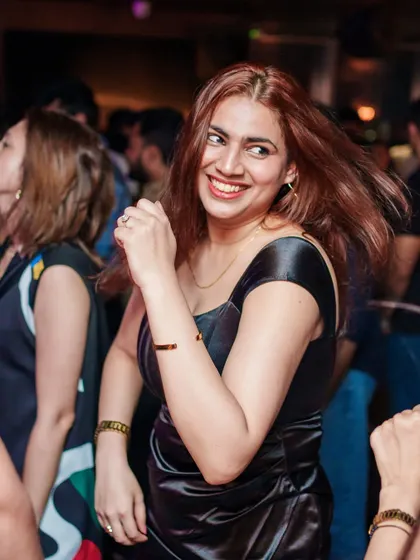 A candid shot of a guest smiling and dancing, a perfect representation of the happy energy at Kaze.