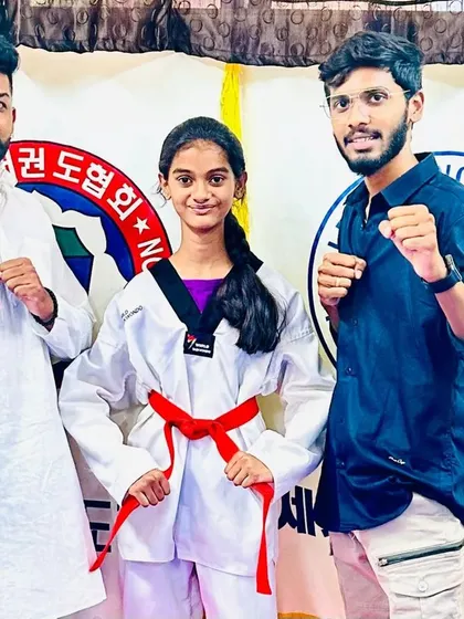 A young lady celebrates her new red belt.