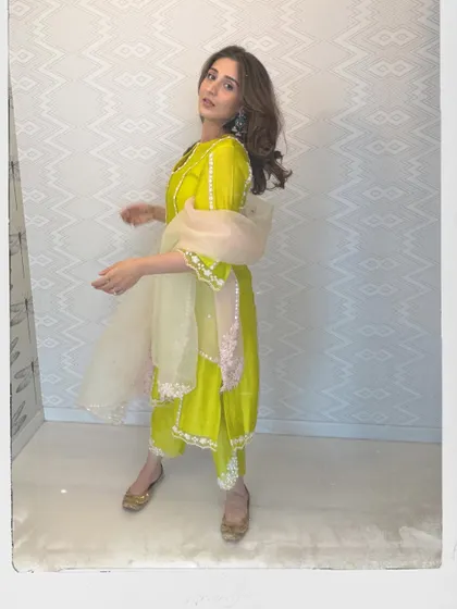 A different perspective of the vibrant lime green suit, styled with traditional juttis. The polaroid effect gives it a lovely, nostalgic feel.