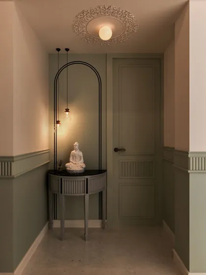 This hallway nook features a serene Buddha statue on a modern console table, framed by a painted arch. It’s a perfect example of creating a peaceful moment in an unexpected place.