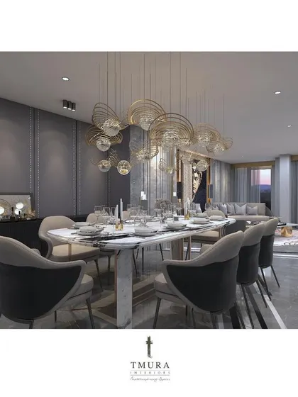 The dining area is seamlessly integrated with the living room, unified by a consistent palette of grey marble and warm wood tones. The sculptural chandelier above the dining table acts as a focal point, defining the space while maintaining an open feel.