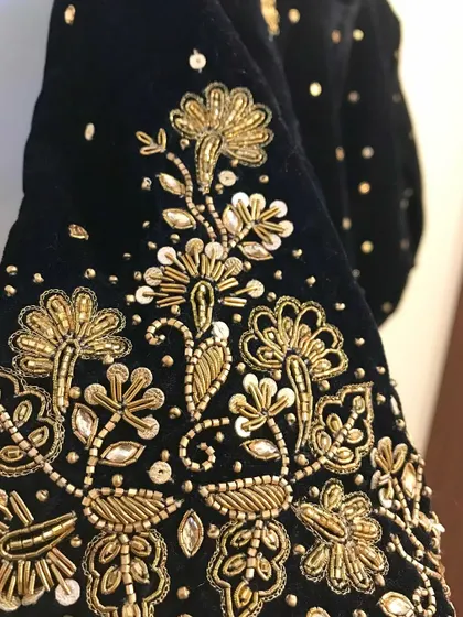 A close-up showcasing the beauty of hand embroidery on velvet. This piece features intricate floral motifs created with zardosi and sequin work.