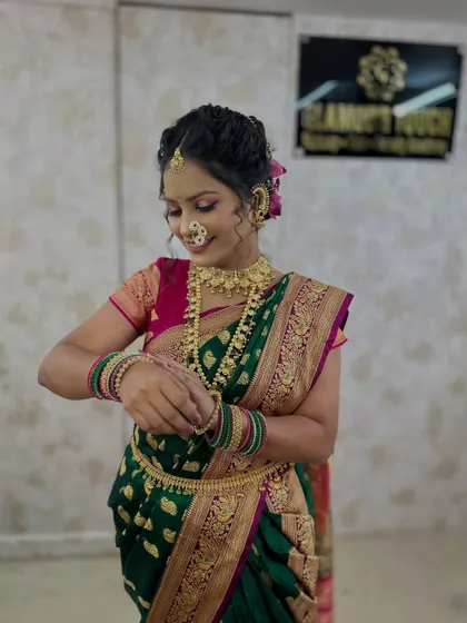 The model admiring her bangles. This shot shows the full effect of the green Nauvari saree, gold jewellery, and the curly hair updo.