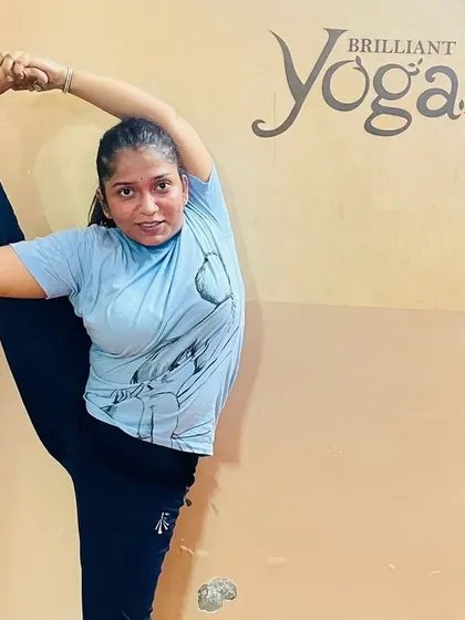 A student shows incredible flexibility and poise in this advanced standing split variation, a result of consistent and dedicated practice in our advanced asana classes.