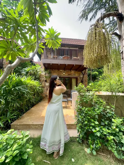 A back view of the white maxi dress, showing off its simple elegance against the beautiful resort background.