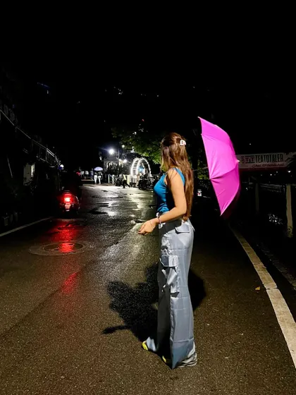 A night shot on a wet mountain road. The reflection of the lights on the street creates a beautiful, moody effect.
