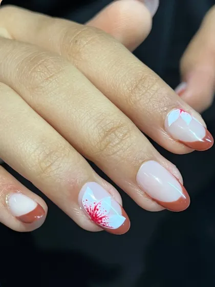 A French manicure kissed by spring flowers. The contrast between the deep red tip and the soft white petals creates a really beautiful and eye-catching design.