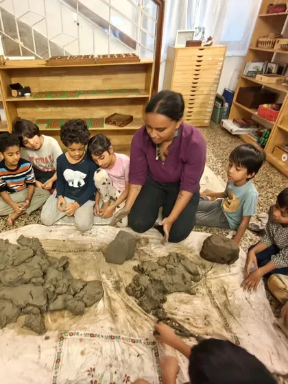 An instructor guides the children, showing them different techniques for working with the natural clay they harvested themselves.