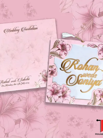 A vibrant pink floral laser-cut invitation with a tassel, combining bright colors with intricate craftsmanship and a gold acrylic name.