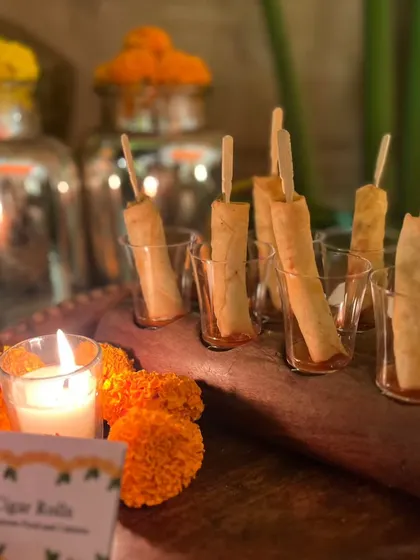 Another look at our elegant Cigar Rolls, served in individual glasses. The warm glow of candles and festive marigold flowers created a perfect ambiance for this Diwali party.