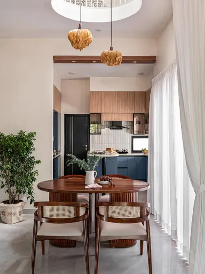 This view shows the dining area's connection to the open kitchen, with the double-height ceiling cutout unifying the two spaces.