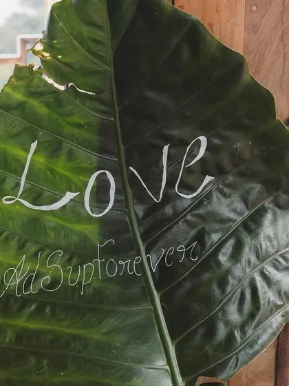 Even our signage is inspired by the location. For this Bali-themed event in Wayanad, we used a large, natural leaf to handwrite the couple's wedding hashtag, blending the decor seamlessly with the environment.