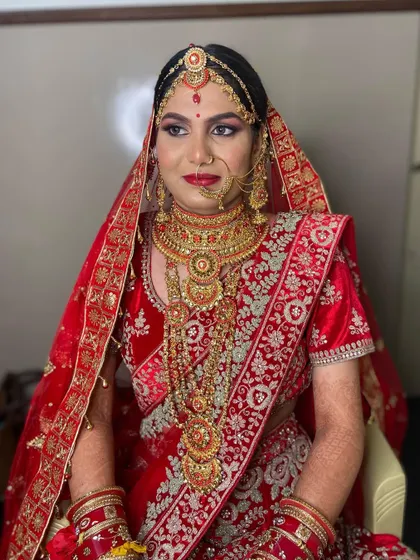 A side profile showcasing the complete traditional bridal attire, from the matha patti to the layered necklaces, all tied together with classic makeup.