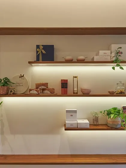 These custom wooden ledges with integrated backlighting serve as a beautiful display for products, books, and decor. It's a simple, elegant solution that adds warmth and character to the bakehouse interior.
