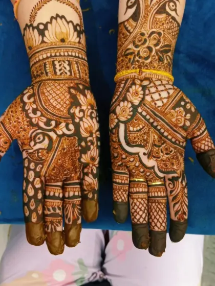 A beautiful bridal design with a mix of peacock and lotus motifs. The dark fingertips are a traditional part of bridal mehandi.