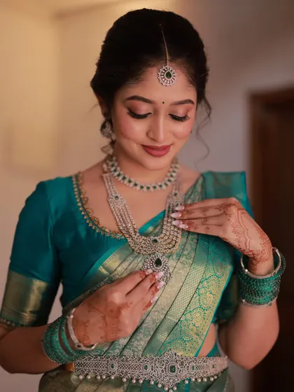 The bride admiring her diamond necklace. This shot highlights the soft contouring and the beautiful shimmer on her eyelids.