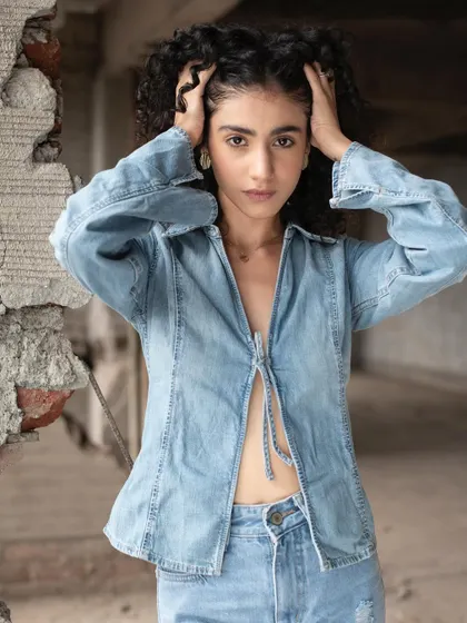 A minimal makeup look designed to enhance the model's features while keeping her beautiful curly hair as the main focus.
