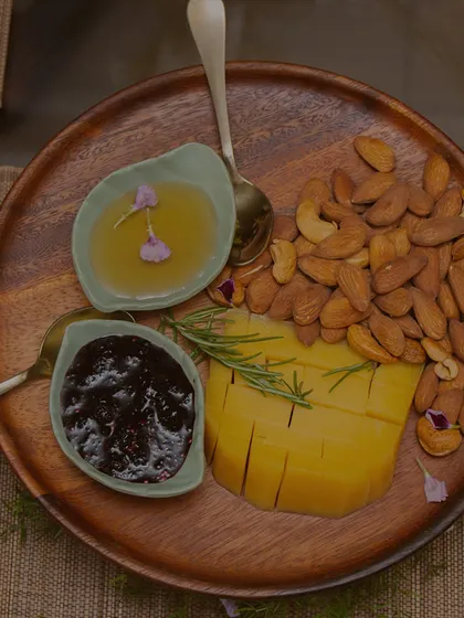 A simple yet elegant platter featuring sliced mango, roasted cashews, and assorted preserves. This offering is perfect for a light, healthy, and upscale snack option.