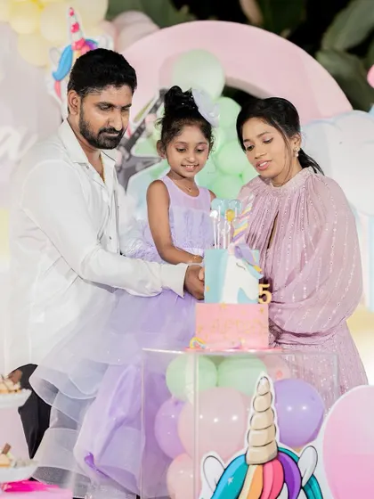 A family celebrating a 5th birthday with a magical unicorn theme.