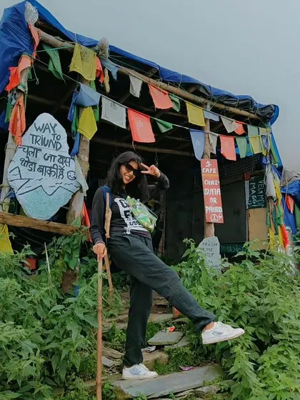 Taking a quick break at a classic mountain cafe on the way to Triund. The prayer flags and rustic charm are all part of the Himalayan trekking experience.