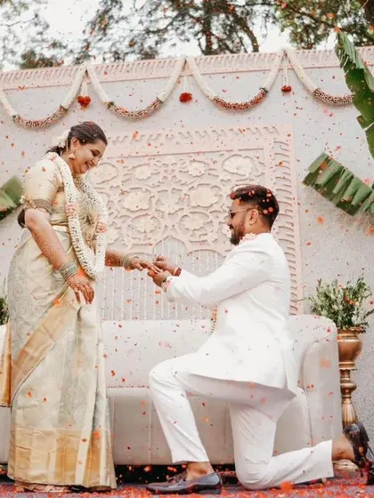 A beautiful proposal during a traditional South Indian engagement ceremony, with guests showering the couple in flower petals.