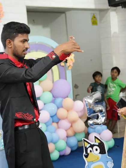 Engaging with the audience is key to my performance. In this photo, I am performing a close-up illusion for a guest, creating a personal moment of wonder amidst the party celebrations.