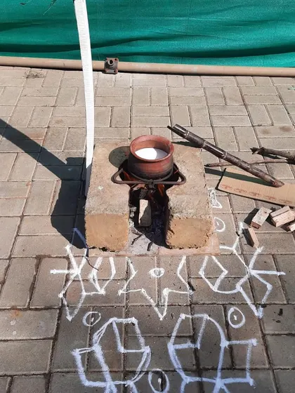 A traditional setup for the harvest festival, with a rangoli and an earthen pot on a brick stove. We believe in giving children authentic cultural experiences.