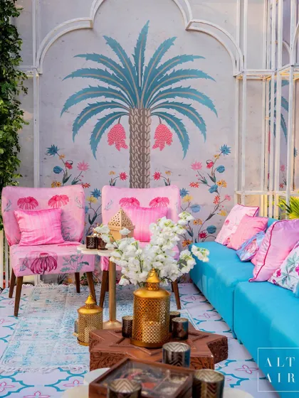 A lounge area from 'Botanical Marrakesh', where hand-painted palm tree murals and vibrant pink and blue fabrics created a botanical oasis with the colors of Marrakesh.