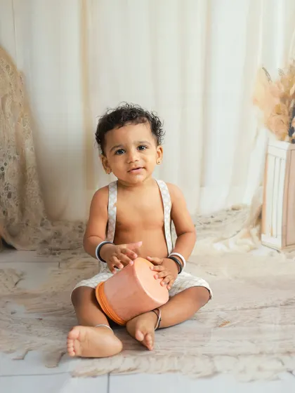 A simple and classic portrait of a baby boy in a boho-inspired setup. The neutral tones and soft textures create a warm and inviting feel.