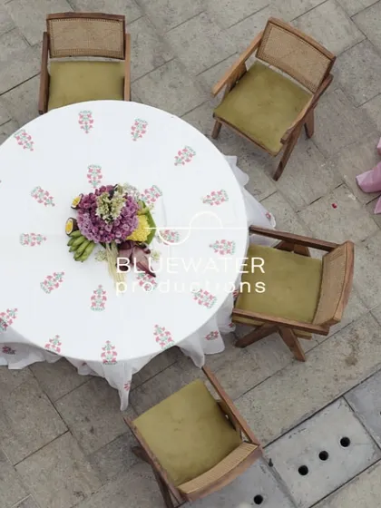 An aerial view of a guest table at the Haldi, showing the printed tablecloth and simple floral centerpiece.