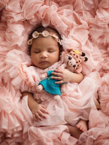 Back to sleep, cuddling a tiny friend. Adding a small stuffed animal can make the photo even sweeter and more personal, especially if it's a special toy.